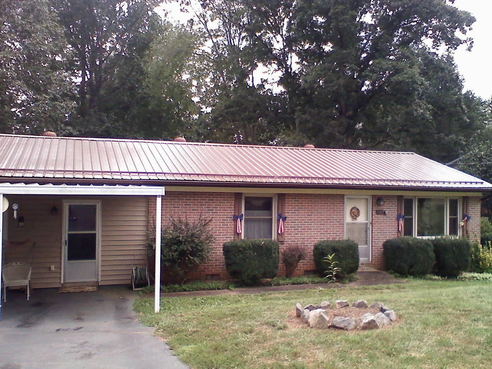 Bronze metal roof and carport on a brick ranch home — Roof Repair work by our crew in Whitestown